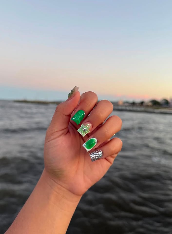 Green gem nail set photographed by the water