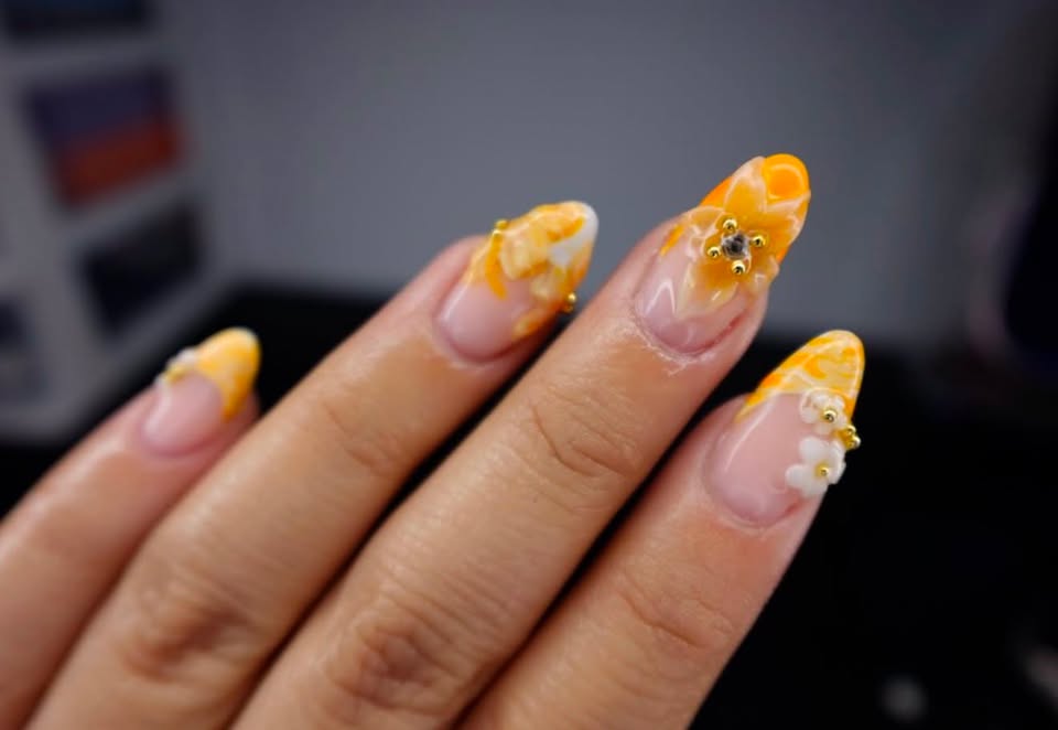 Orange almond nails with floral and gold details